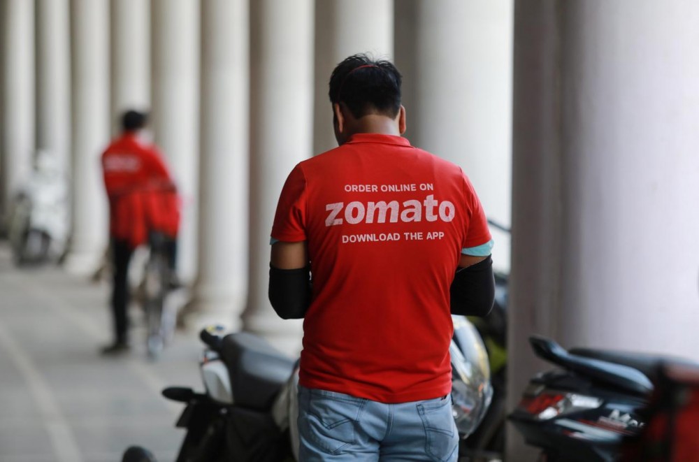 A delivery worker of Zomato waits to collect an order from a restaurant, during an extended nationwide lockdown to slow the spread of the coronavirus disease (COVID-19), in New Delhi, India, May 21, 2020. (REUTERS/Anushree Fadnavis/File photo)